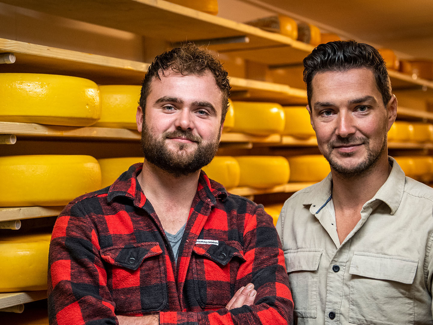 foto met Kaasmeesters Corné en Paul in de kaaskelder met hun goudse kazen op houten planken