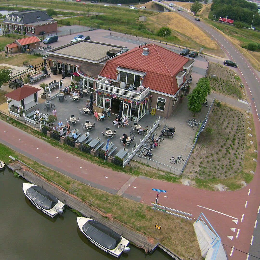 luchtfoto van het pand en terras van eetcafe de bonte haas en de luxe en comfortabele sloepen die voor het terras in het water liggen in het Westland