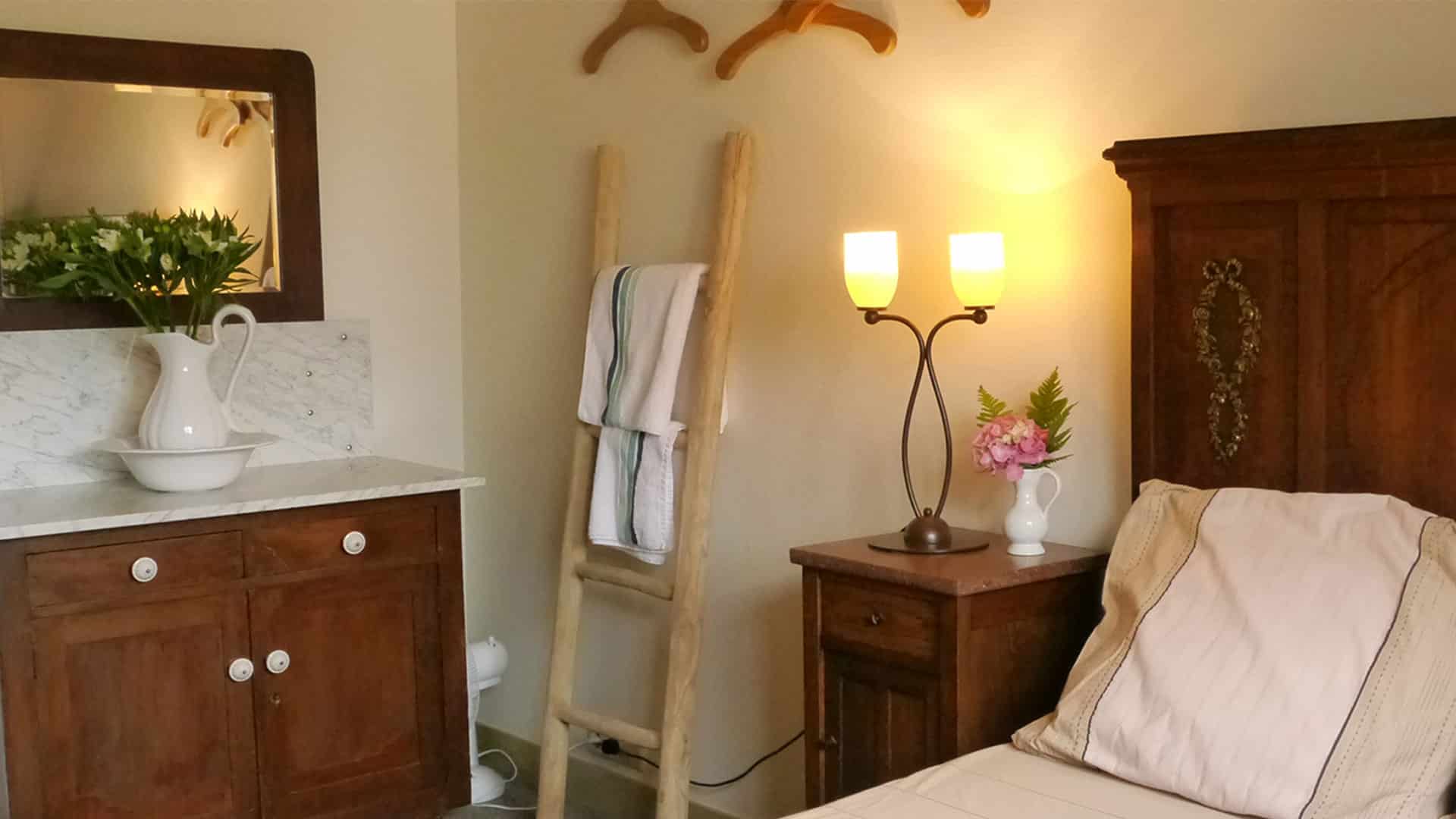 slaapkamer bij B&B De Hooiberg met houten bed en dressoir met lampetkan en spiegel in 't Woudt in Midden-Delfland