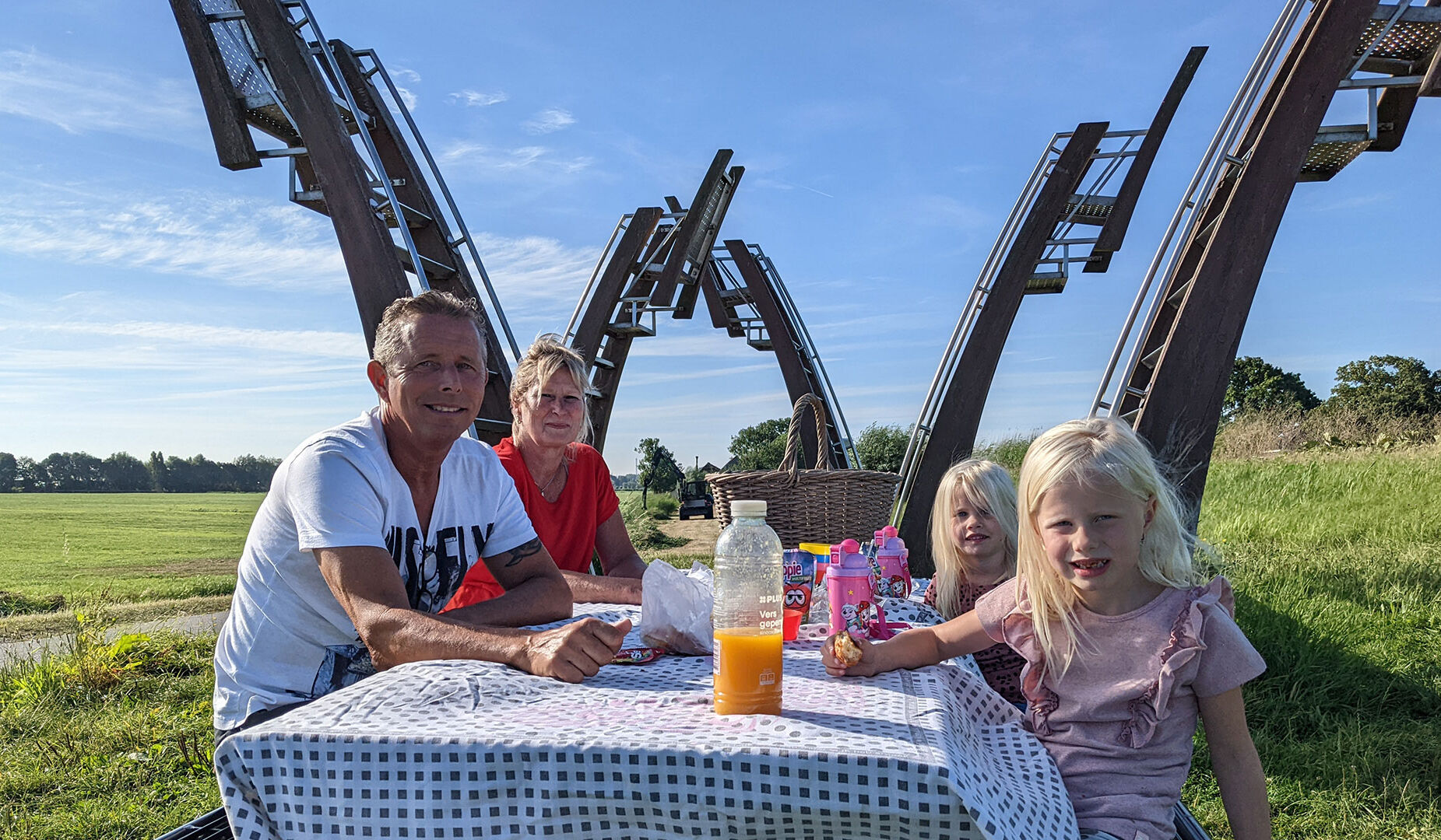 Gert en vrouw ontbijten met kleinkinderen bij de hoge stoelen langs de Vlaardingervaart in Midden-Delfland op een zonnige ochtend zomer 2022