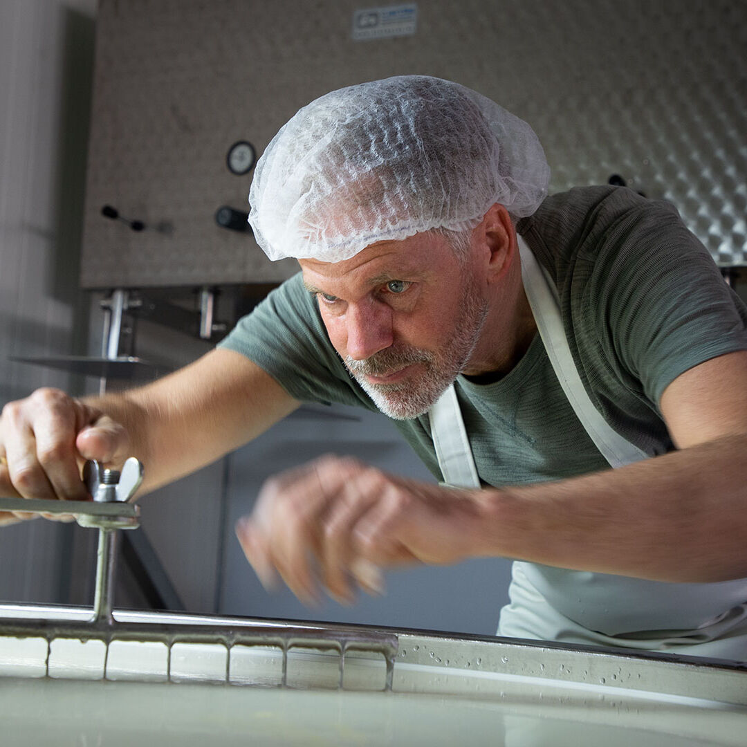 kaasmeester Riens in een zuivelruimte waar kaas gemaakt wordt bij het controleren van de kaas voor De Kaasmeesters uit Midden-Delfland streekproduct makers