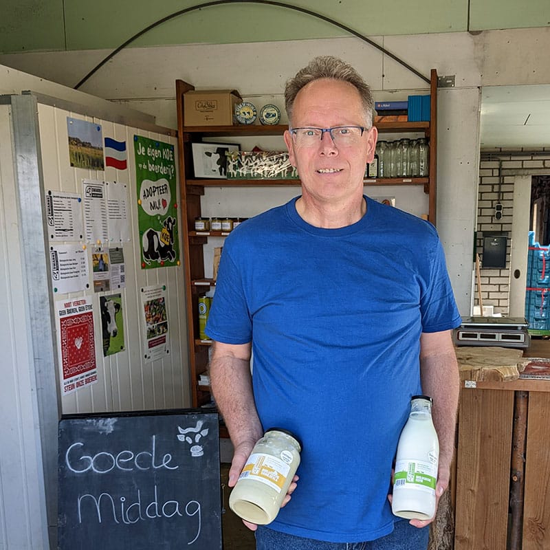 Jeroen van der Kooijvan hoeve Rust-hoff in zijn streekproductenwinkel met twee flessen zuivel van Hoeve Rust-hoff in zijn handen kefir yoghurt melk maker in midden-delfland boer