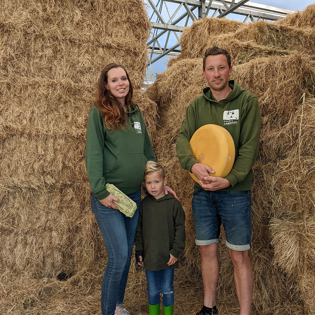 Boer Roel, Femke en Levi van Buuren van Boerderij Landlust in hun schuur in Midden-Delfland met kaas en eieren met in de achtergrond hooibalen streekproduct maker