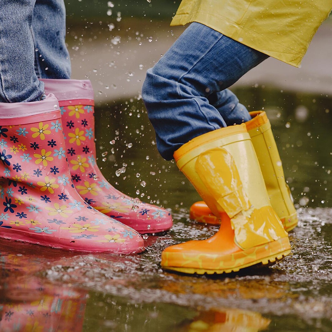 Buitenspelen kinderen laarzen in de regen