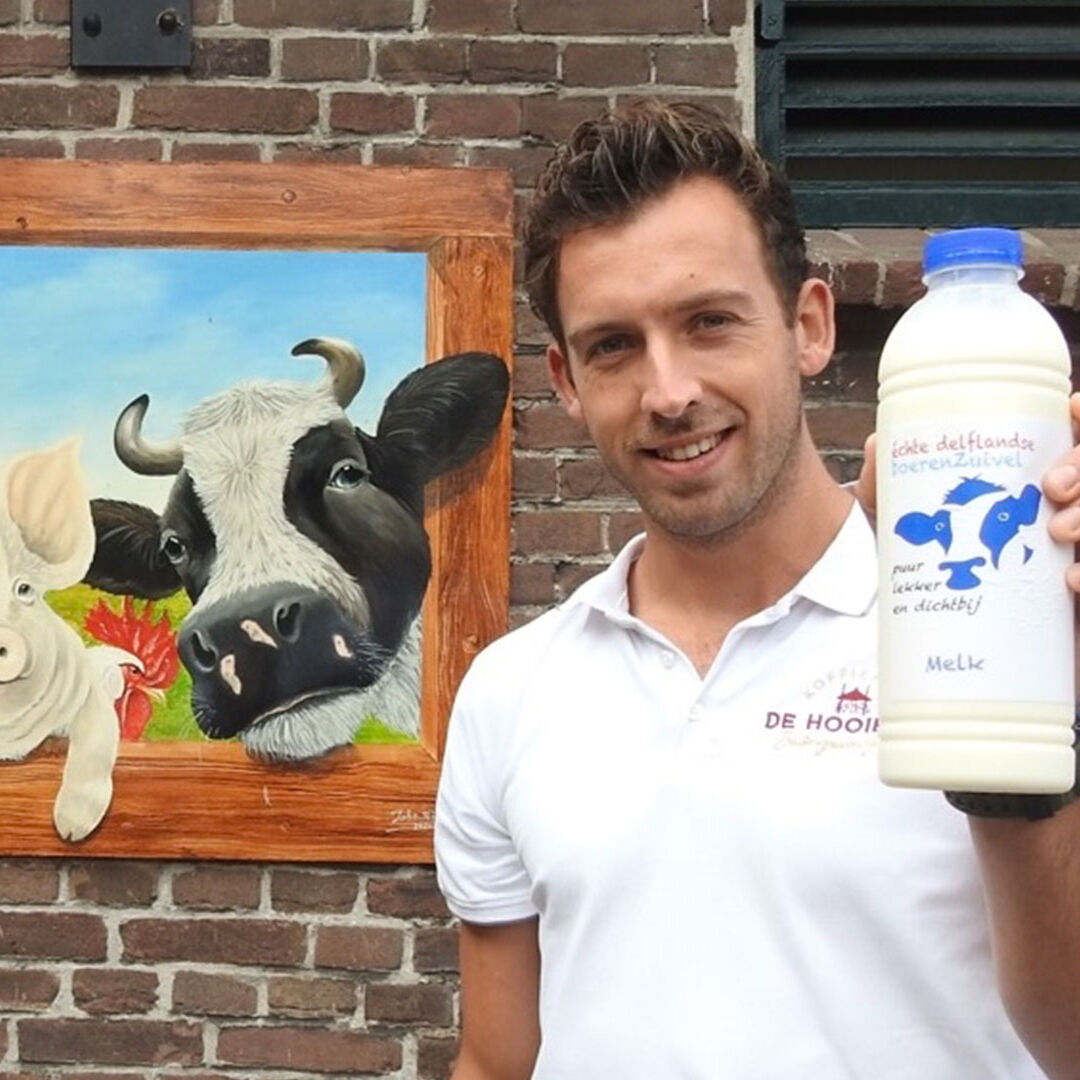 Robin van Vliet met een fles melk van Delflandshof uit Midden-Delfland bij koffiehuis de Hooiberg in Midden-Delfland