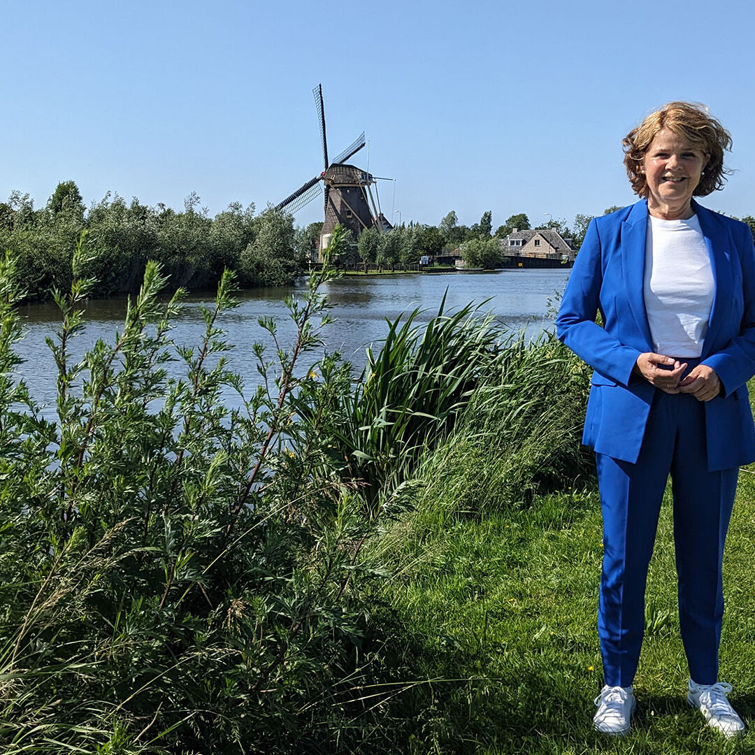 Marja van Bijsterveld op de dijk in Schipluiden naast de Vlaardingsevaart en in de achtergrond de molen op een zonnige dag voor de column MD door de ogen van